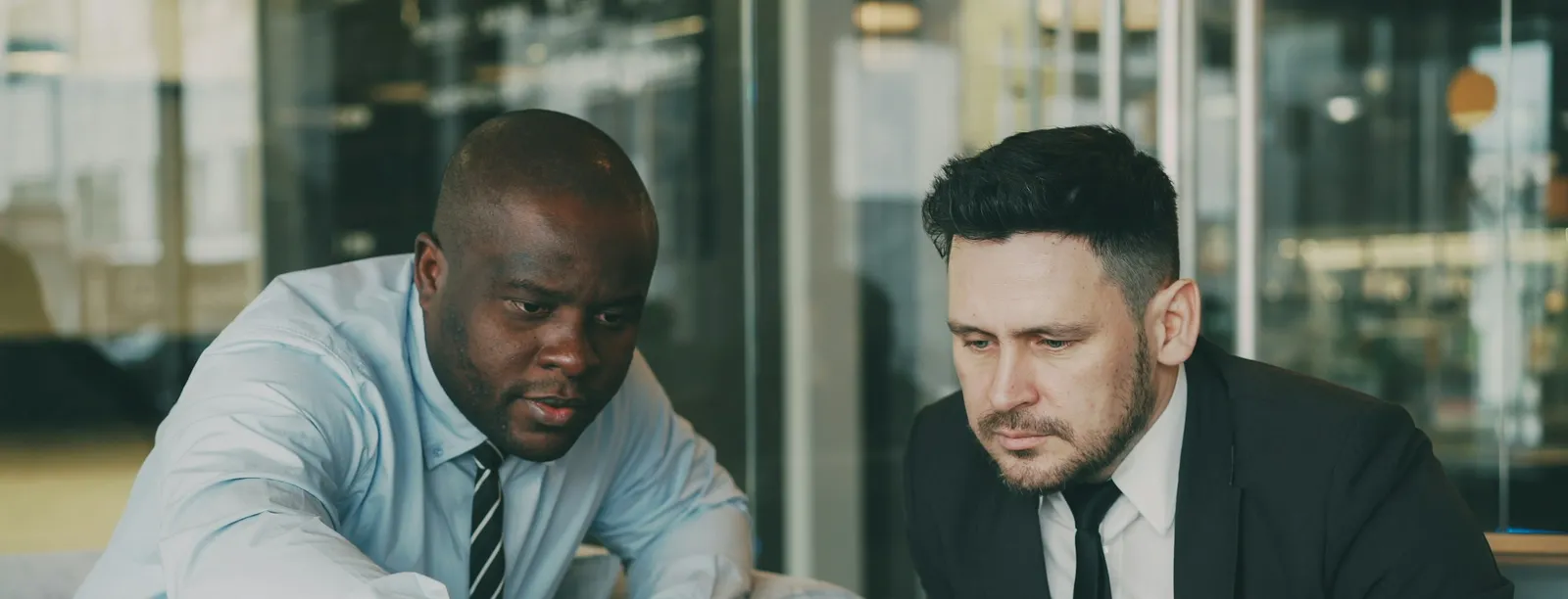 Dos profesionales analizando un proyecto en una laptop en una oficina moderna
